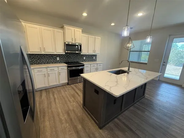 a kitchen with a stove sink and cabinets