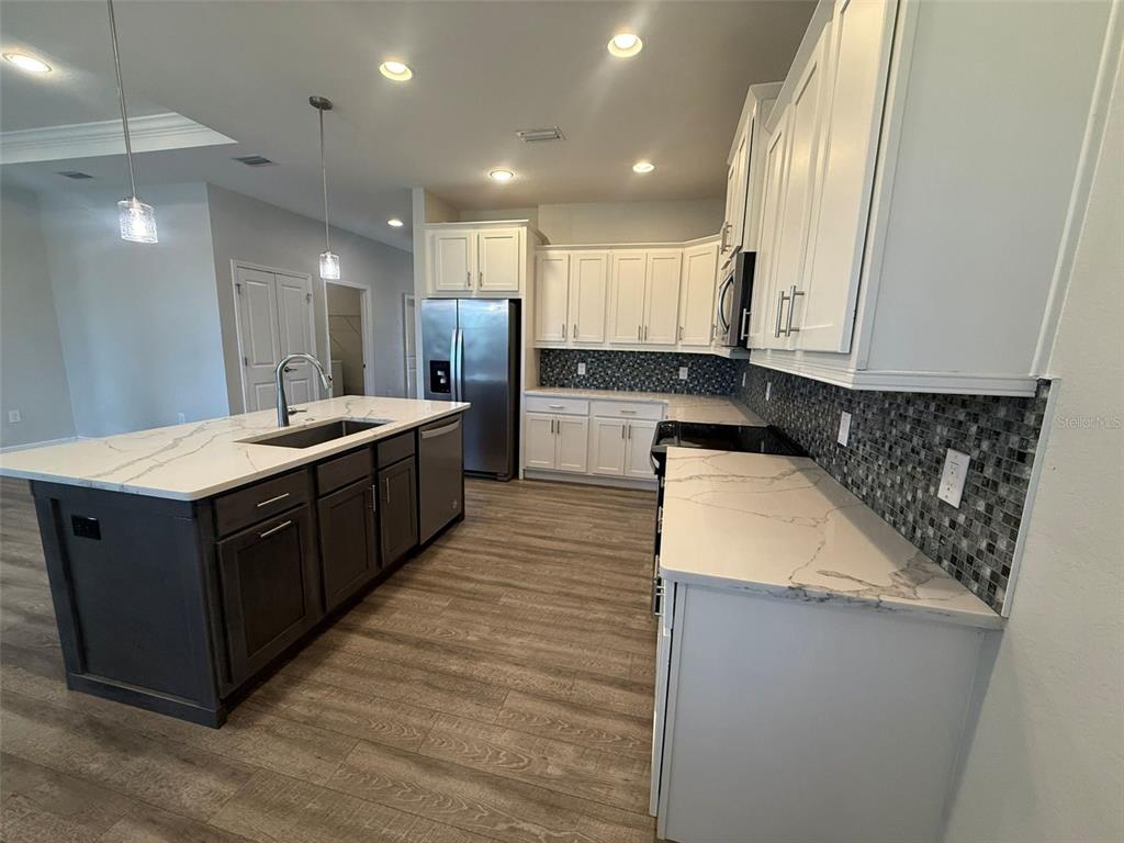 26265 Explorer Road Punta Gorda, FL 33983 - Photo 6 of 15 a large kitchen with stainless steel appliances kitchen island granite countertop a sink and a stove