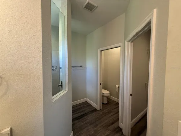 a bathroom with a glass door shower and a toilet