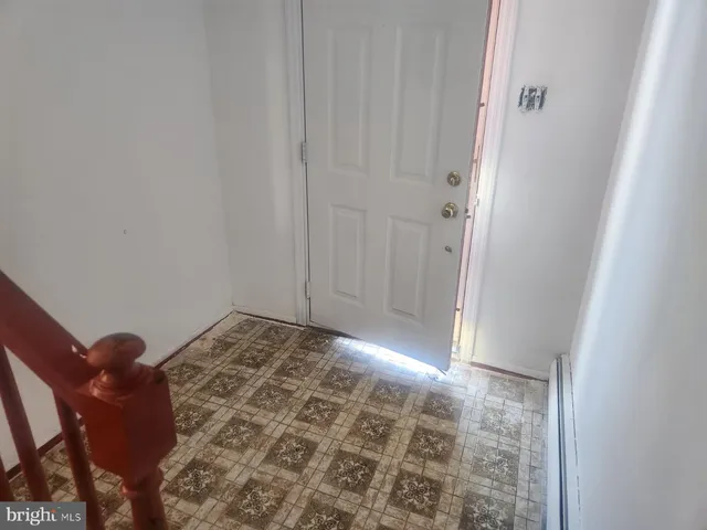 a view of an empty room with wooden floor fireplace and a window