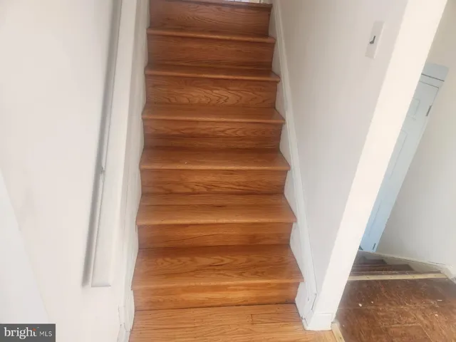 a view of a hallway with entryway door with wooden floor
