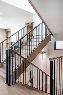 a view of staircase with railing and white walls
