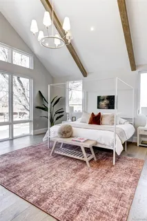 a bedroom with a bed a large window and flat screen tv
