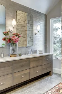 a bathroom with a sink mirror and cabinets