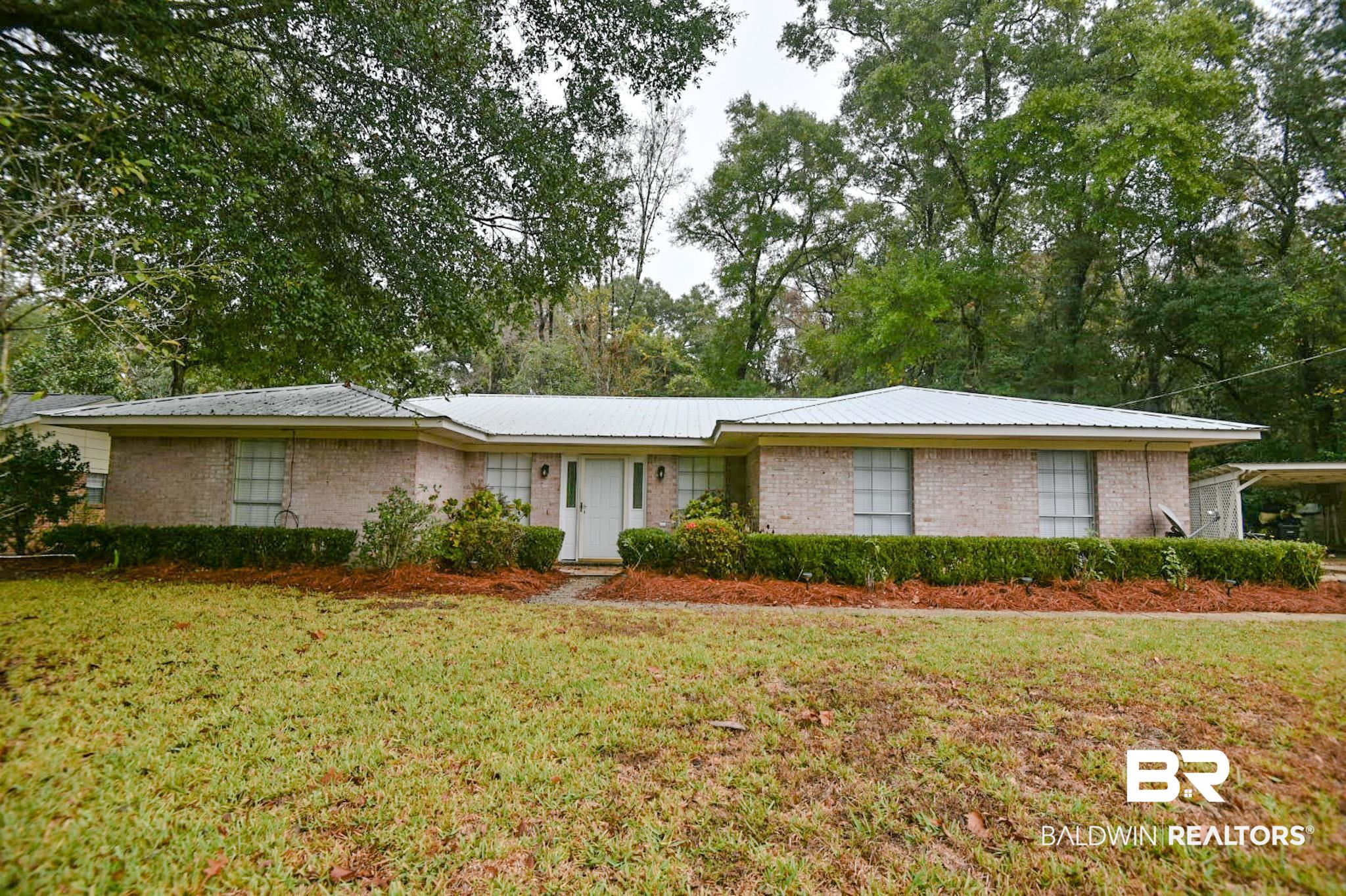 90 Paddock Drive Fairhope, AL 36532 - Photo 2 of 23 Ranch-style house featuring a front yard, brick siding, and view of wooded area