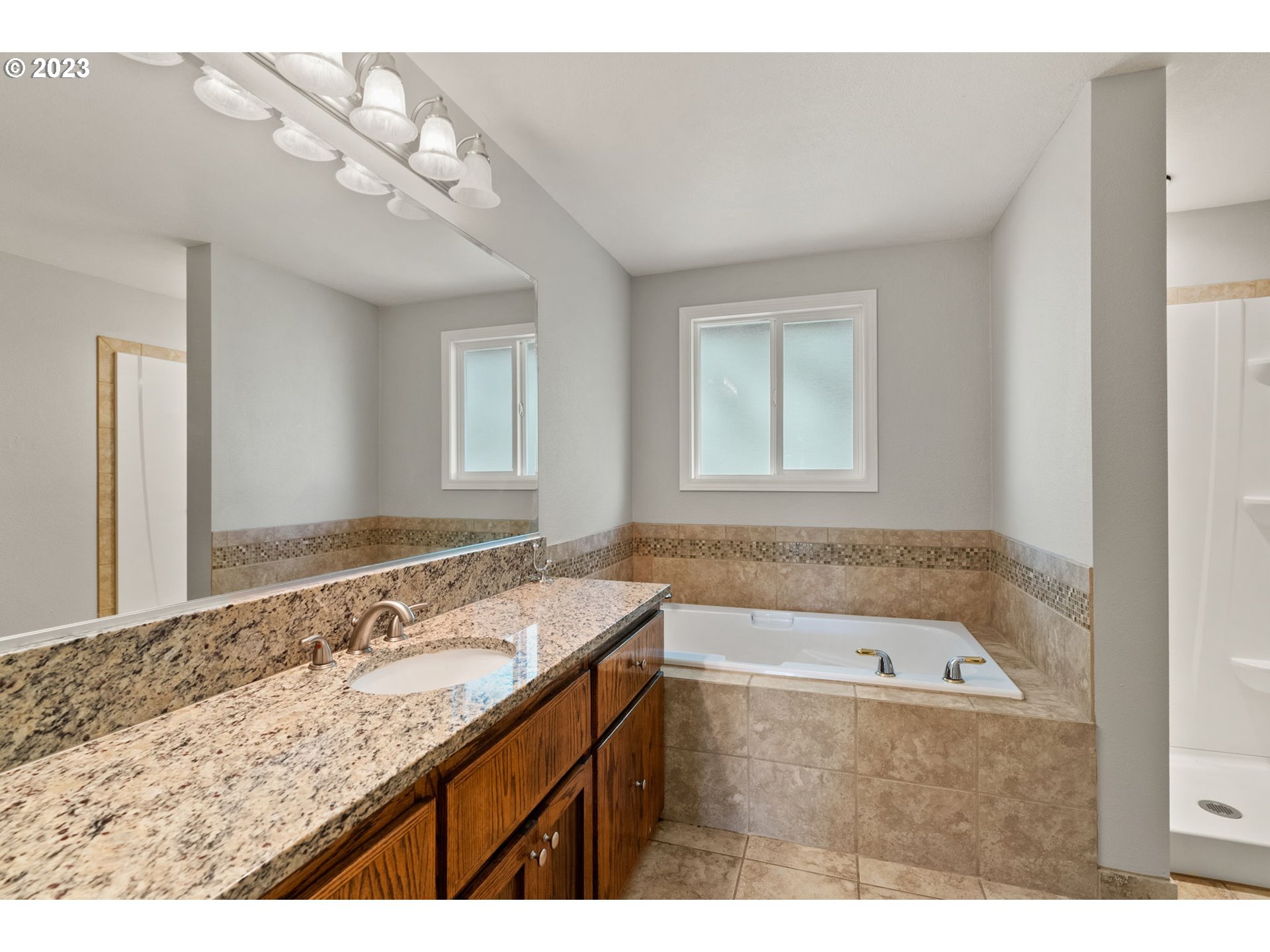 31170 Southwest Firdale Road Cornelius, OR 97113 - Photo 24 of 46 a bathroom with a granite countertop sink a large mirror and a bathtub
