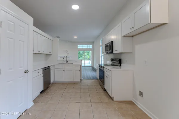 a kitchen with a sink window and cabinets