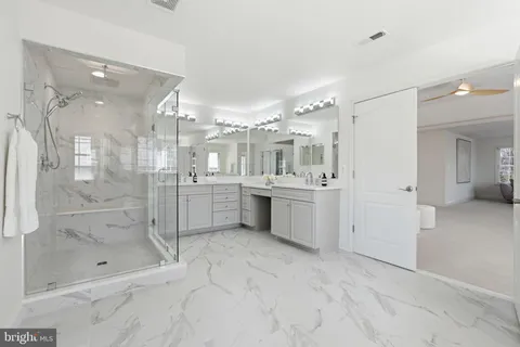 a bathroom with a granite countertop double vanity and a mirror