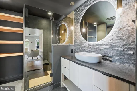 a living room with furniture large windows and wooden floor