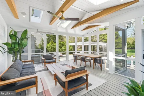 a view of a patio with table and chairs with wooden floor and fence