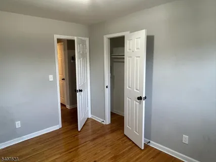 an empty room with wooden floor and entrance