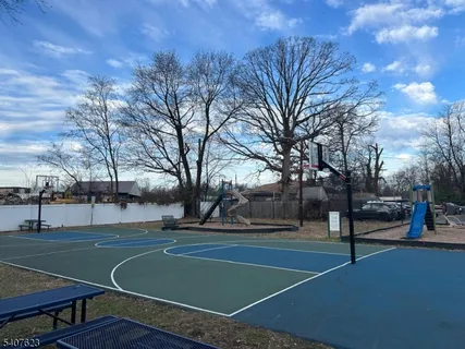 a view of a tennis ground with large trees