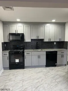 a kitchen with granite countertop a stove a sink and a microwave
