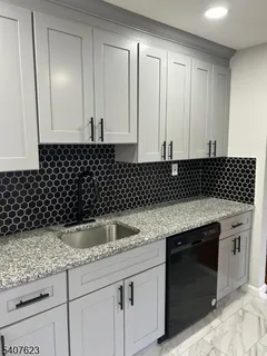 a kitchen with granite countertop a sink and a stove