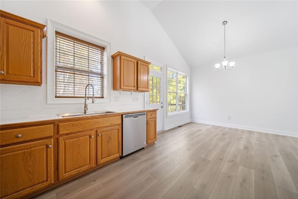 2140 Wildcat Cliffs Way Lawrenceville, GA 30043 - Photo 12 of 32 a kitchen with granite countertop wooden cabinets a sink and dishwasher with wooden floor