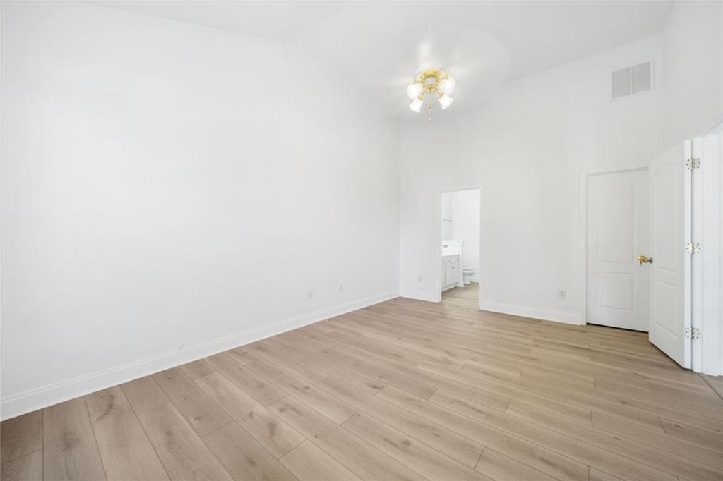 2140 Wildcat Cliffs Way Lawrenceville, GA 30043 - Photo 18 of 32 a view of an empty room with wooden floor and a chandelier