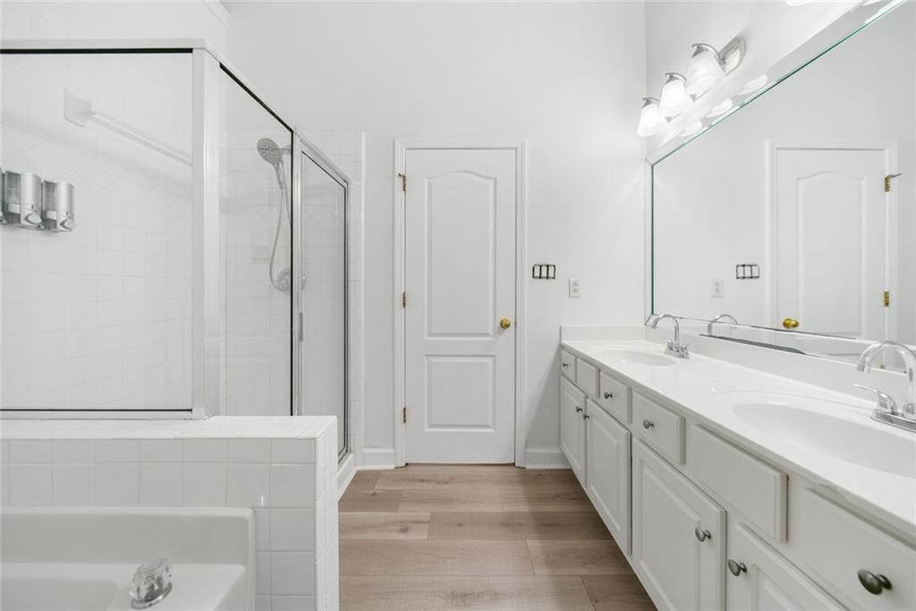 2140 Wildcat Cliffs Way Lawrenceville, GA 30043 - Photo 21 of 32 a spacious bathroom with a double vanity sink a mirror and a bathtub