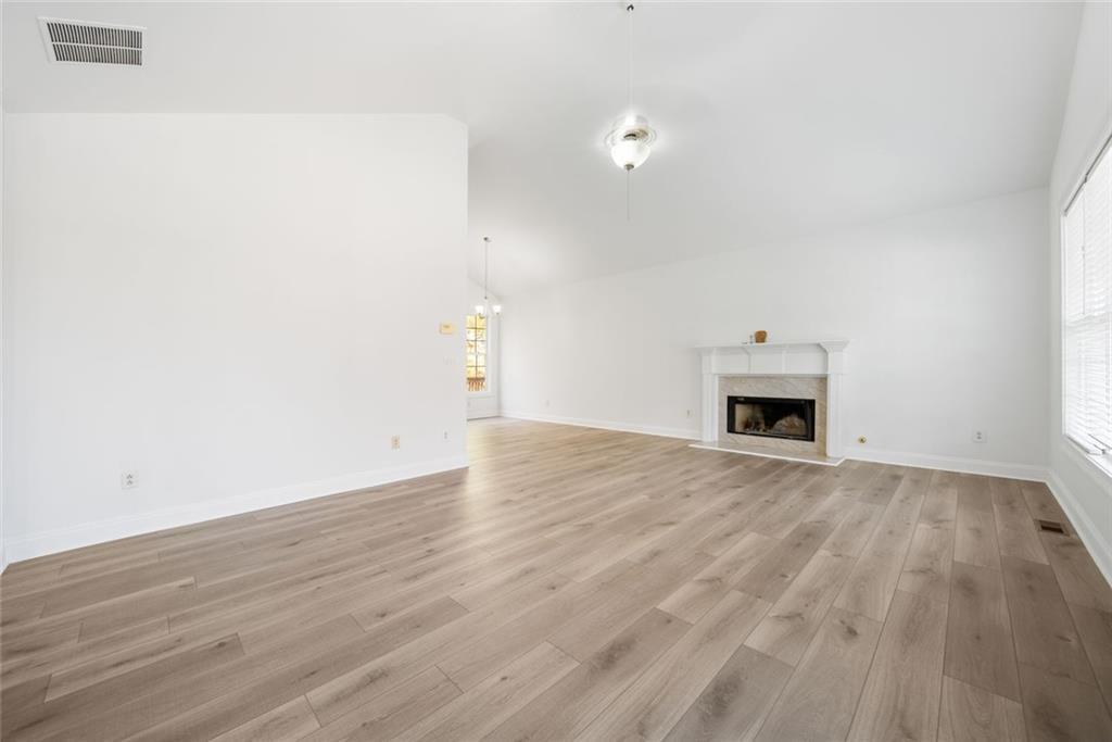 2140 Wildcat Cliffs Way Lawrenceville, GA 30043 - Photo 7 of 32 an empty room with wooden floor and fireplace