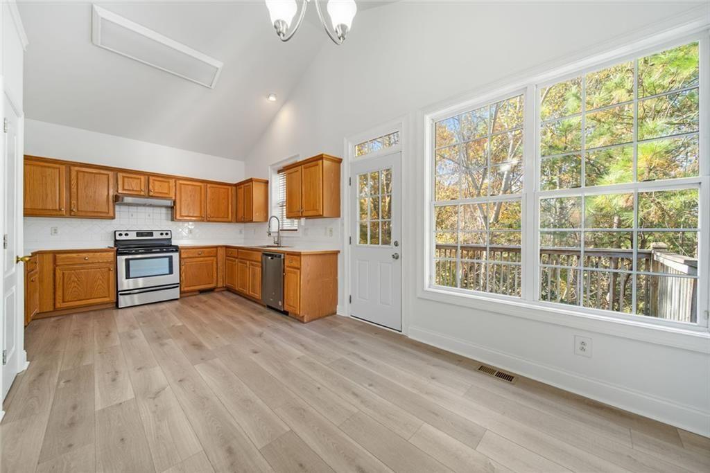 2140 Wildcat Cliffs Way Lawrenceville, GA 30043 - Photo 10 of 32 a view of kitchen with stainless steel appliances granite countertop a stove top oven a refrigerator and a view of living room