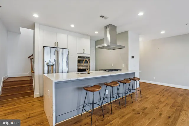 a kitchen with stainless steel appliances a refrigerator and a stove top oven