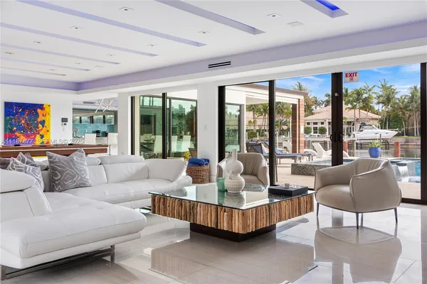 a dining room with furniture large windows and wooden floor