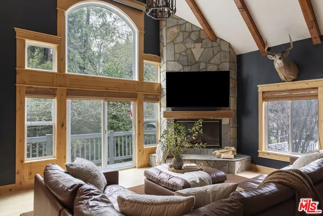 a living room with fireplace furniture and a large window