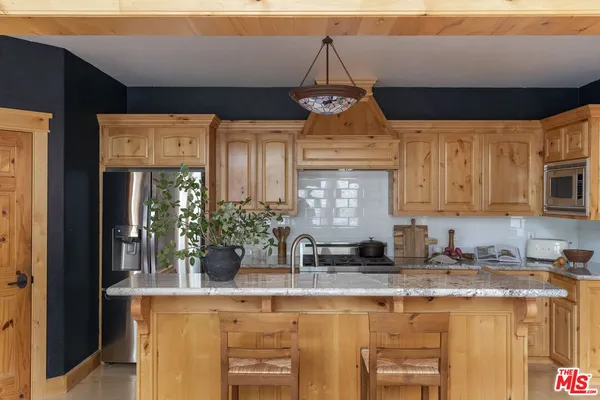 a kitchen with a counter space cabinets and a chandelier