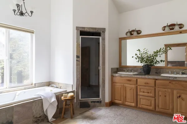 a spacious bathroom with a granite countertop sink and a mirror