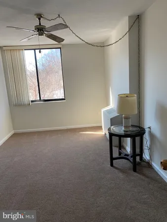a view of empty room with windows and fan