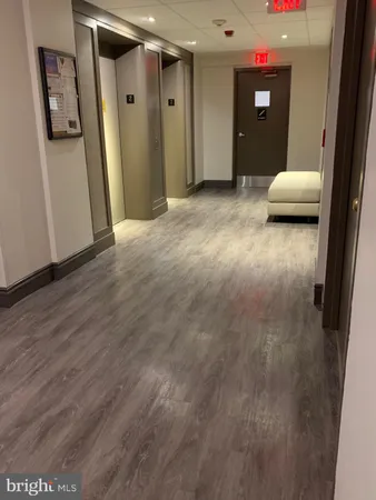 a view of a hallway with wooden floor and closet
