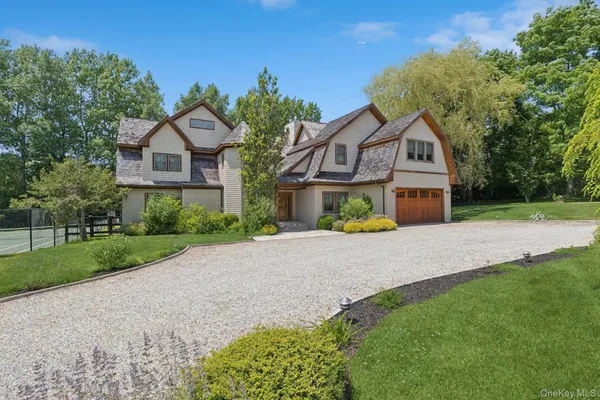 a front view of a house with a yard and trees