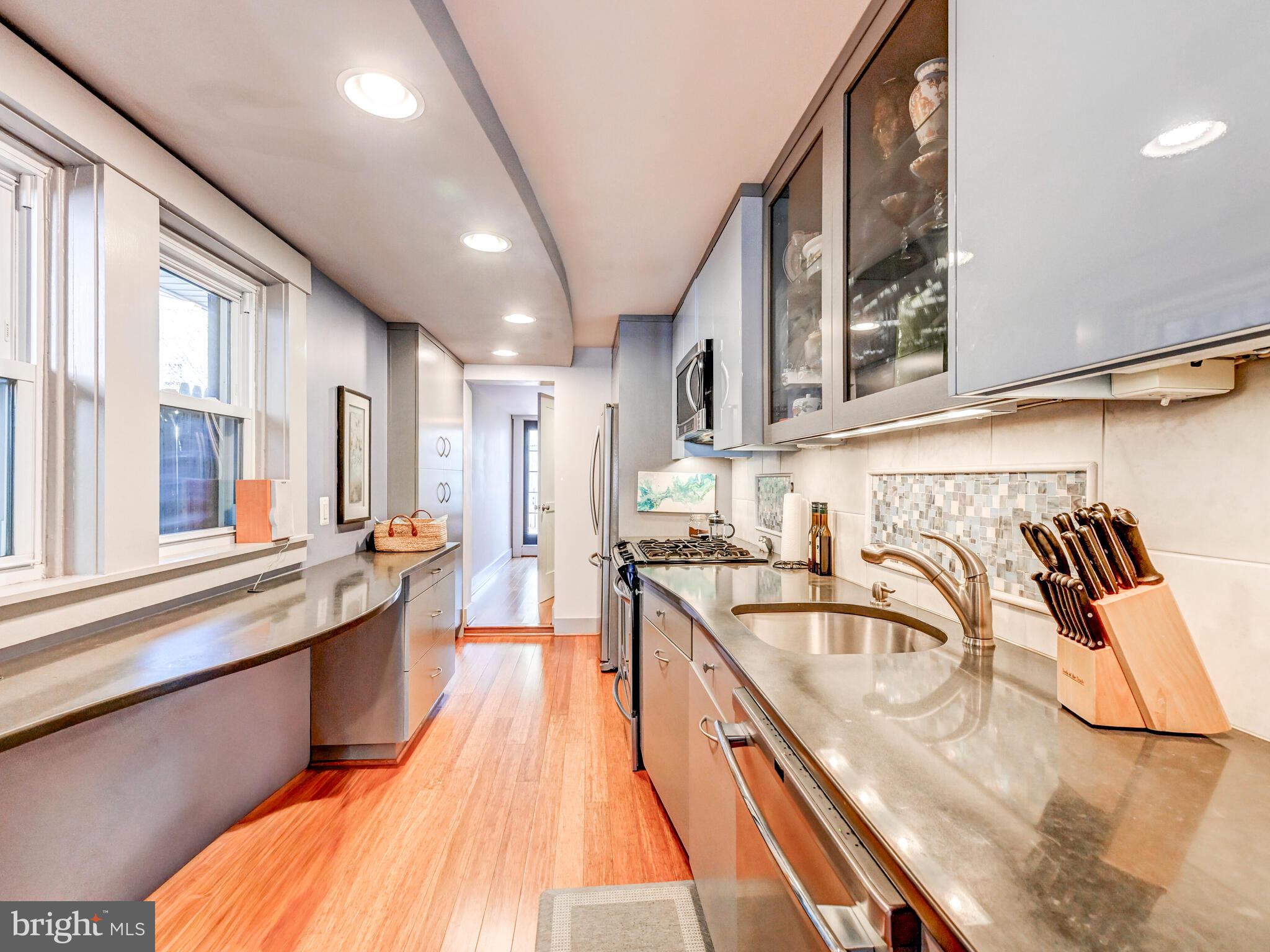 325 South Castle Street Baltimore, MD 21231 - Photo 6 of 31 a kitchen with stainless steel appliances granite countertop a sink a stove and a wooden floors