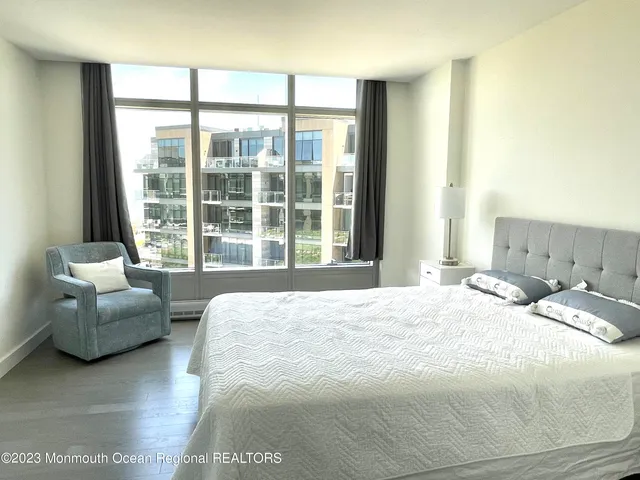 a bedroom with a bed and a large window