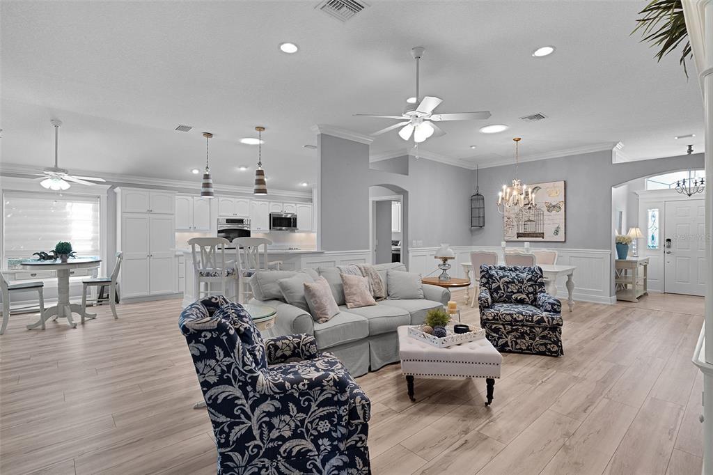 2211 Bachman Path The Villages, FL 32162 - Photo 4 of 60 a living room with furniture kitchen view and a chandelier