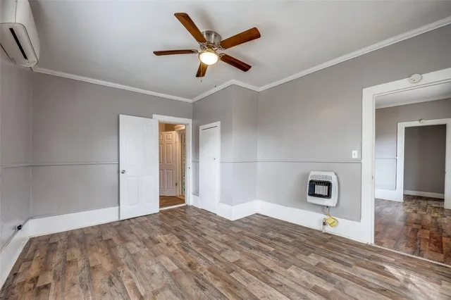 a view of empty room with wooden floor and ceiling fan