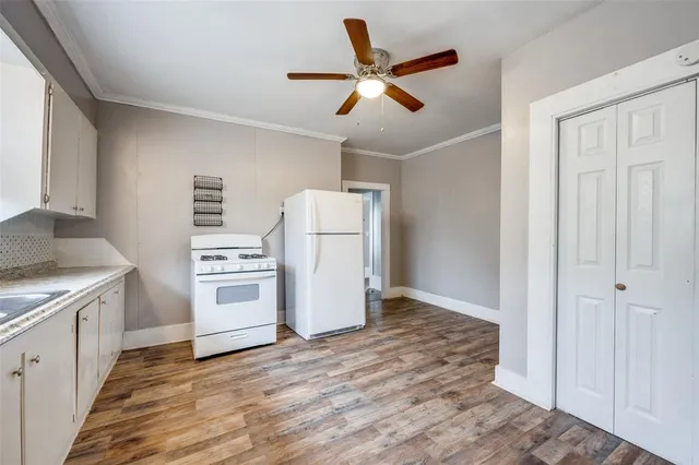 a view of a kitchen with granite countertop white cabinets and wooden floor