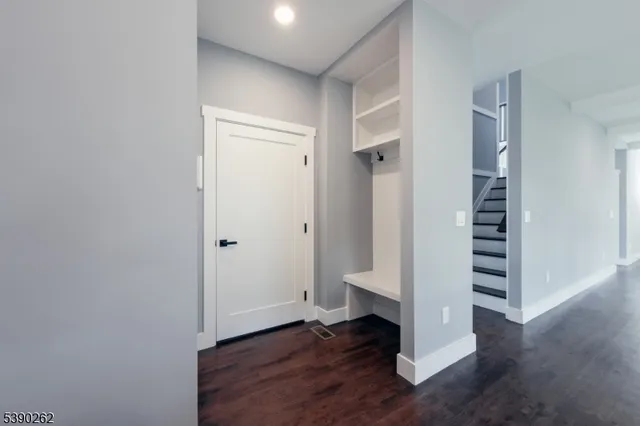 an empty room with wooden floor & entryway