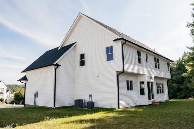 a view of a white house with yard and sitting area