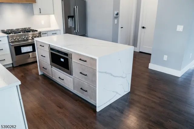 a kitchen with a stove and a wooden floor