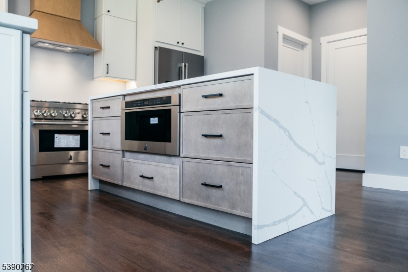 4 Hemlock Circle Warren, NJ 07059 - Photo 7 of 28 a kitchen with stainless steel appliances white cabinets and wooden floor