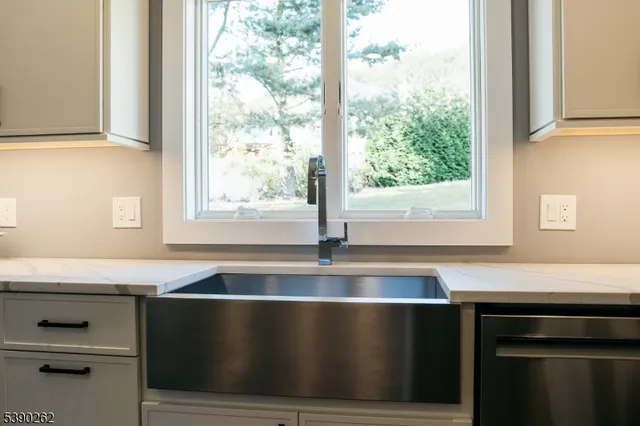 a kitchen with a sink a large window and a wooden floor