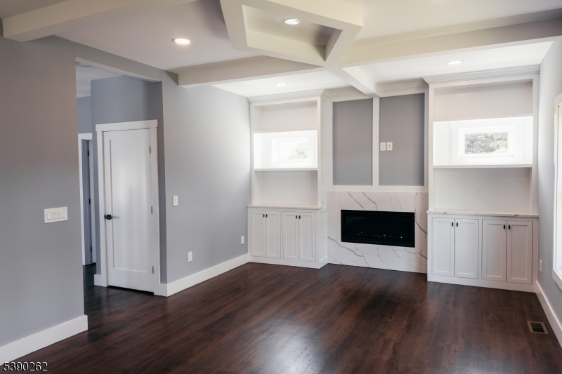 4 Hemlock Circle Warren, NJ 07059 - Photo 9 of 28 an empty room with wooden floor fireplace and staircase