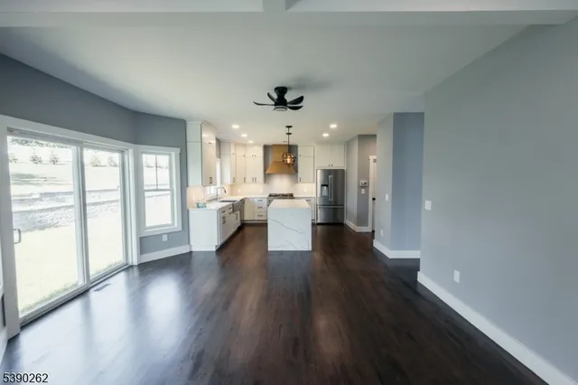a view of a kitchen with wooden floor and a window