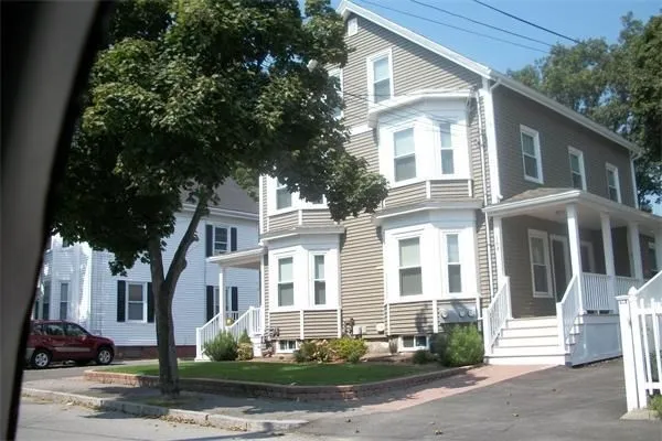 a front view of a house with a tree
