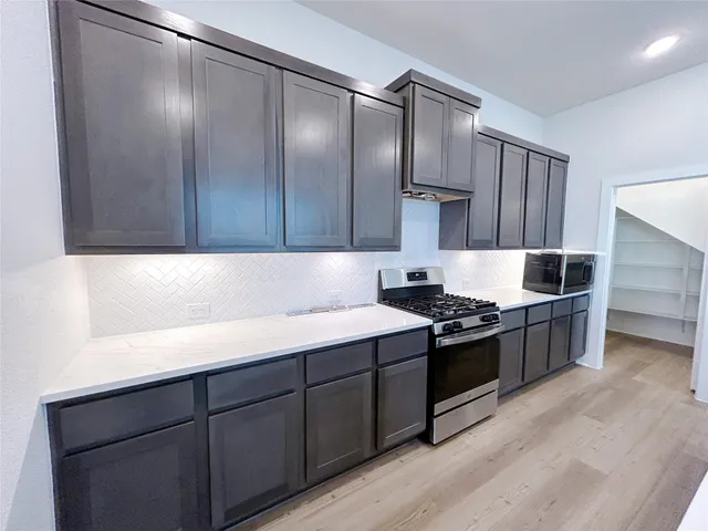 a kitchen with stainless steel appliances granite countertop a stove and a refrigerator