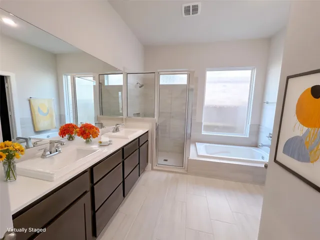 a bathroom with a sink double vanity mirror and a bathtub