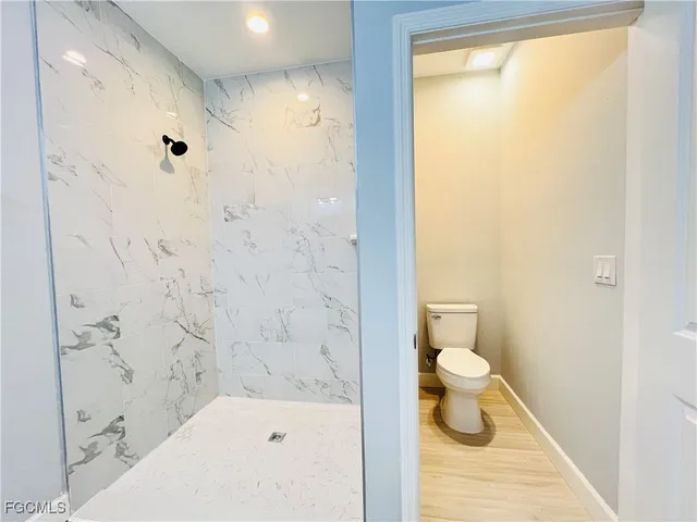 a bathroom with a toilet and a shower