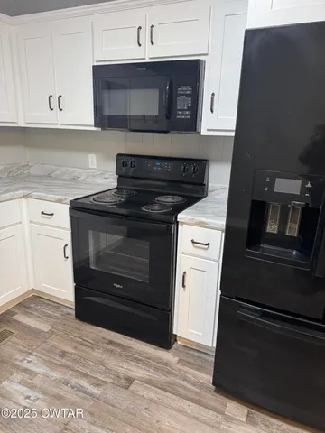 a kitchen with granite countertop white cabinets and stainless steel appliances