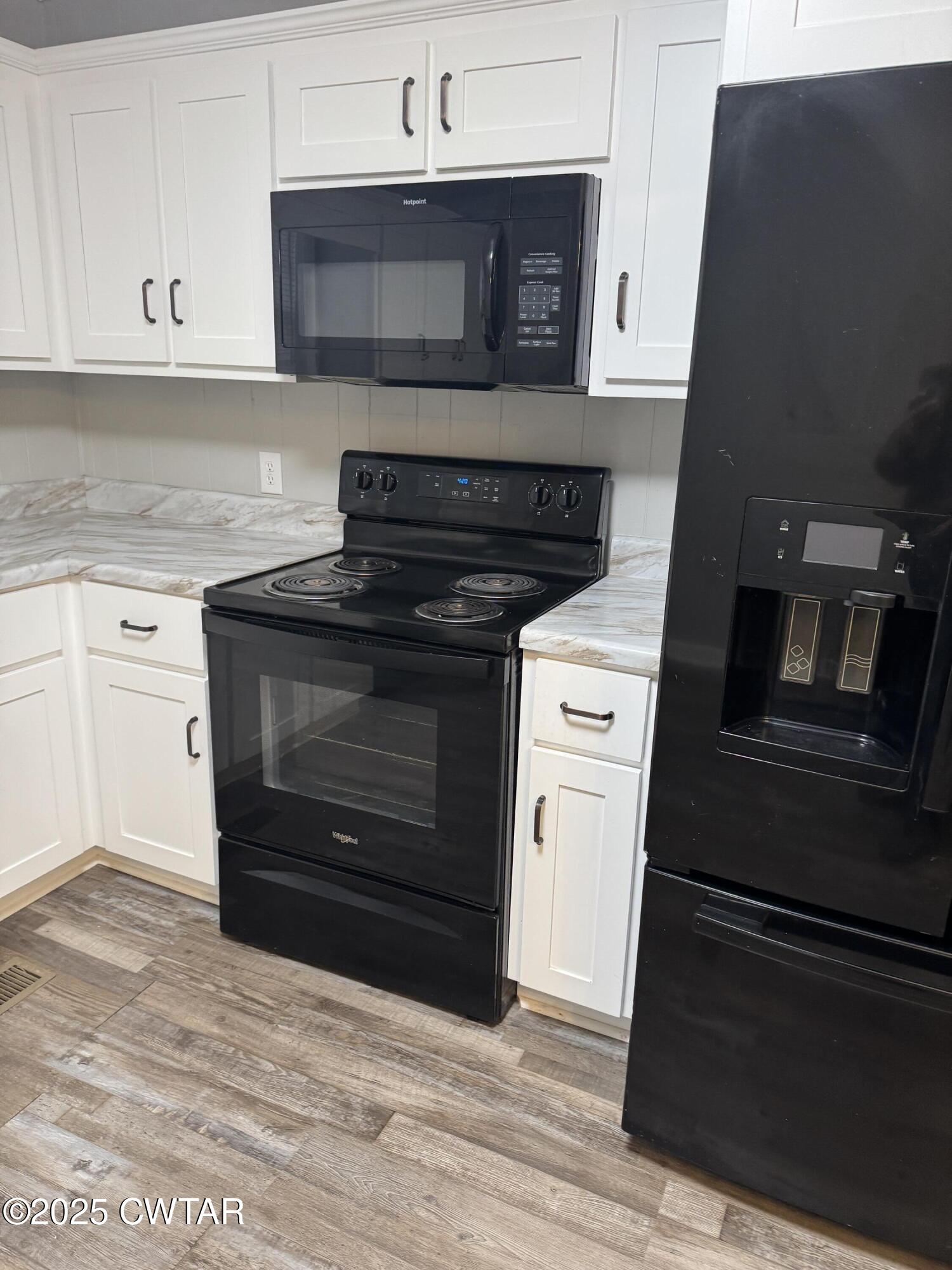 380 Patterson Lane Finger, TN 38334 - Photo 16 of 25 a kitchen with granite countertop white cabinets and stainless steel appliances