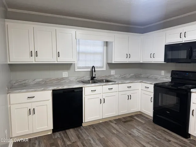 a kitchen with granite countertop cabinets stainless steel appliances and a sink
